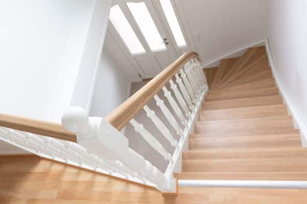 Hvid indendørs kvartsvingstrappe, trætrappe fra Vejletrappen med smukke balustre og trappetrin i eg.