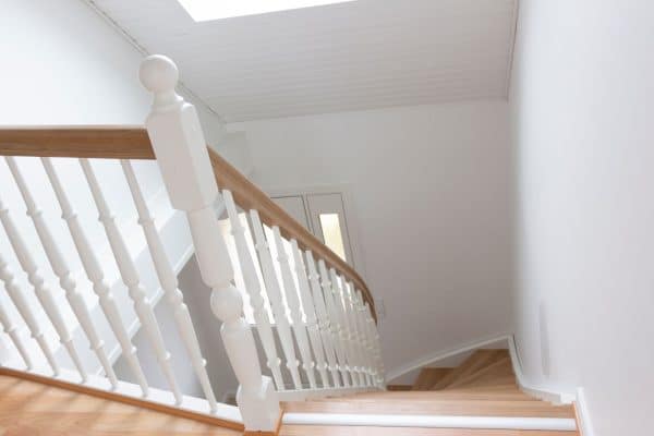 Hvid indendørs kvartsvingstrappe, trætrappe fra Vejletrappen med smukke balustre og trappetrin i eg.