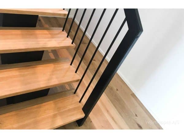 Trætrappe designet som en ligeløbstrappe med trappegelænder med sorte vange samt trappetrin i eg fra Vejletrappen