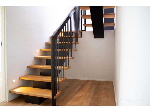 Trætrappe designet som en ligeløbstrappe med trappegelænder med sorte vange samt trappetrin i eg fra Vejletrappen