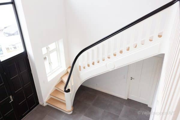 Hvid trætrappe designet som en krumningstrappe / kvartsvingstrappe med pladegelænder og med trappetrin og trappegelænder i eg fra Vejletrappen