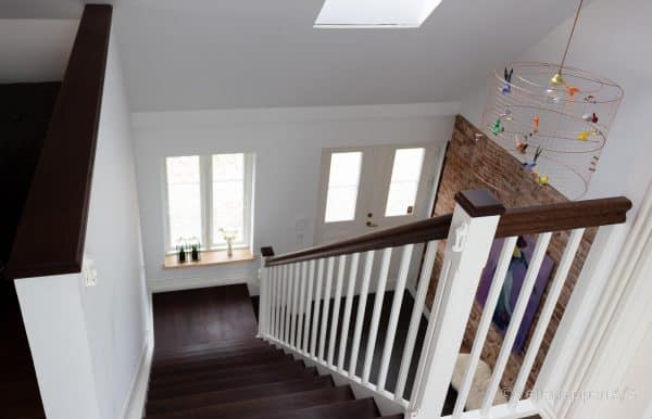 Hvid trætrappe designet som en kvartsvingstrappe med trappetrin og trappegelænder i mørk eg fra Vejletrappen