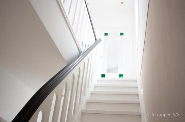 Hvid trætrappe designet som en ligeløbstrappe med pladegelænder og elegant trappebelysning under trin fra Vejletrappen