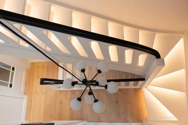 Hvid svungen trætrappe designet som en halvsvingstrappe med pladegelænder fra Vejletrappen