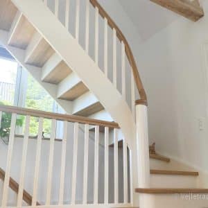 Kvartsvingstrappe fra Vejletrappen. Hvid trappe med hvide balustre, trappetrin og trappegelænder i olieret eg.