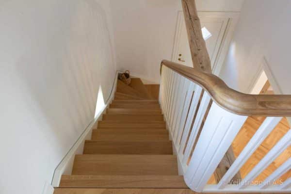 Kvartsvingstrappe fra Vejletrappen. Hvid trappe med hvide balustre, trappetrin og trappegelænder i olieret eg.
