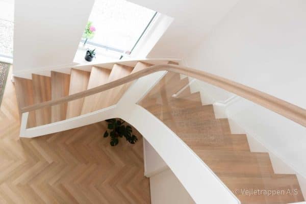 Trætrappe designet som en kvartsvingstrappe / krumningstrappe med glasværn og trappetrin og trappegelænder i eg fra Vejletrappen