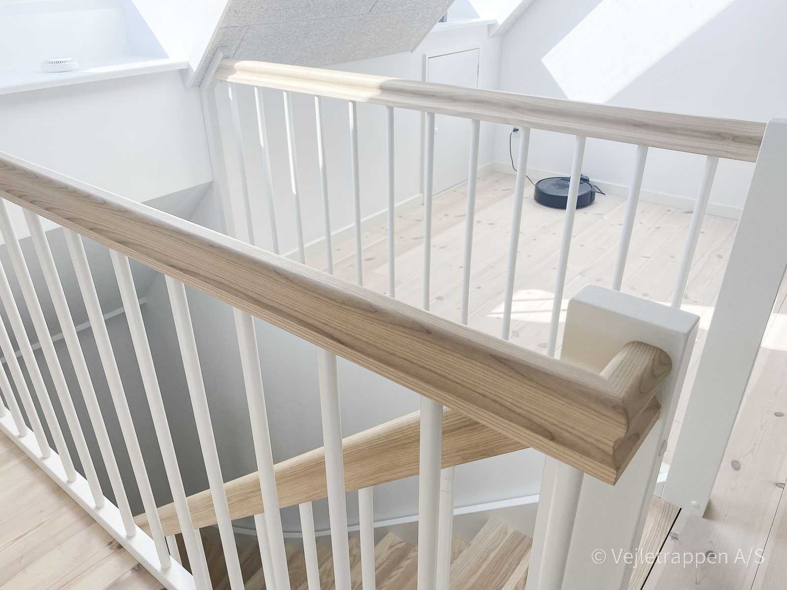 Halvsvingstrappe med trappetrin i eg, monteret som en halvsvingstrappe med trappegelænder med hvide balustre og egetræs gelænder fra Vejletrappen