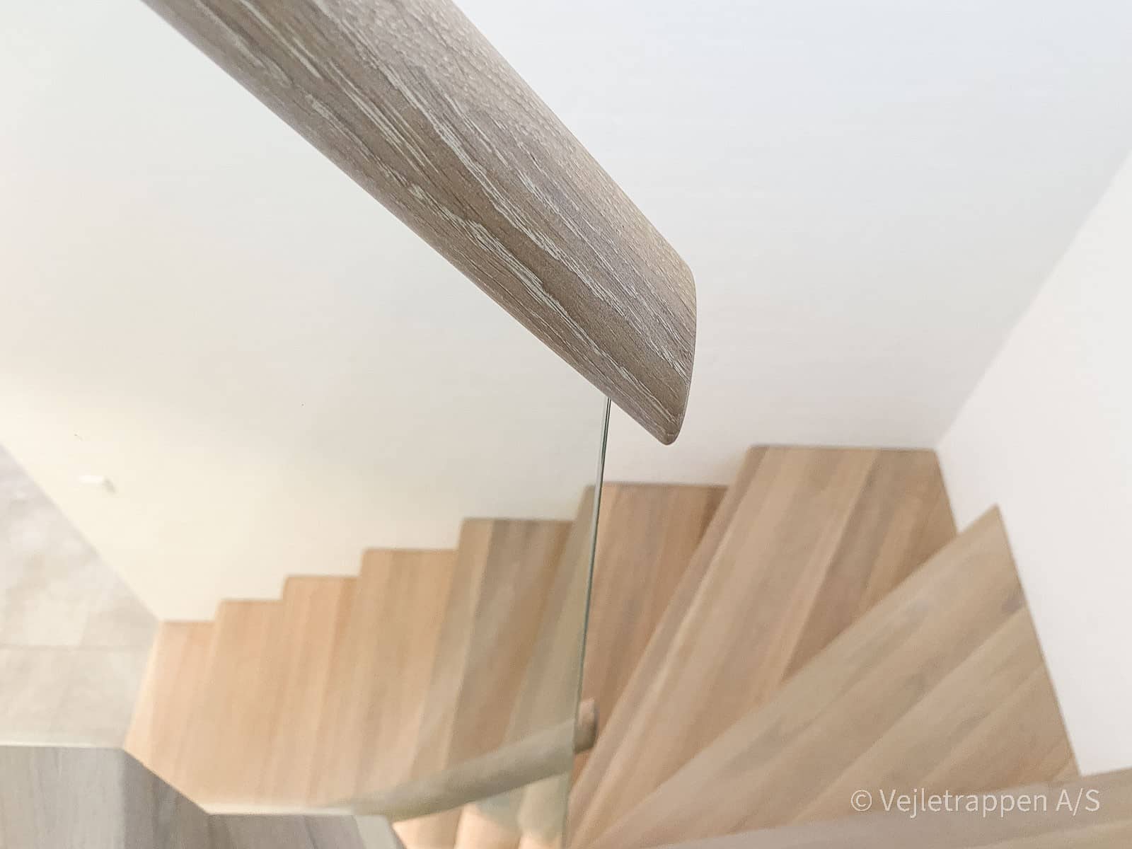 Trætrappe fra Vejletrappen. Halvsvingstrappe i eg, udformet som en musetrappe med glasgelænder, monteret med trappebelysning.